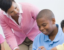 A woman and boy are looking at something on the table.