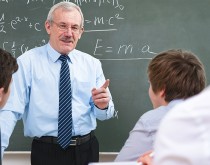 A man in front of a chalkboard with two people.